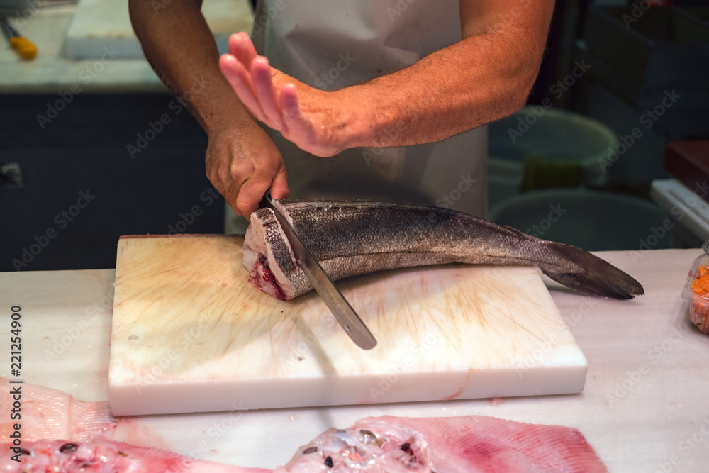 Man cutting slices of Mediterranean fish on Ataranzanas Central Market, Malaga, Spain Man cutting slices of Mediterranean fish on Ataranzanas Central Market, Malaga, Spain