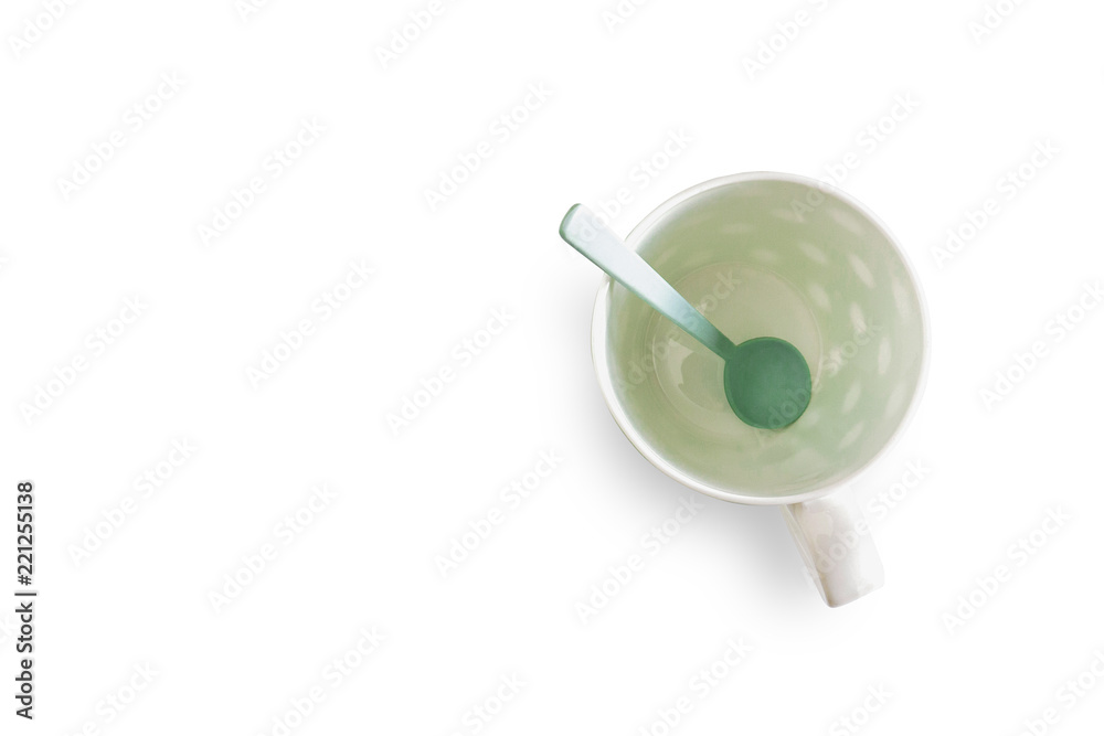 White cup and green spoon separated from the white background with clipping path White cup and green spoon separated from the white background with clipping path