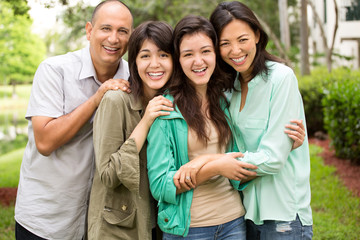 MIxed race family laughing and huging.