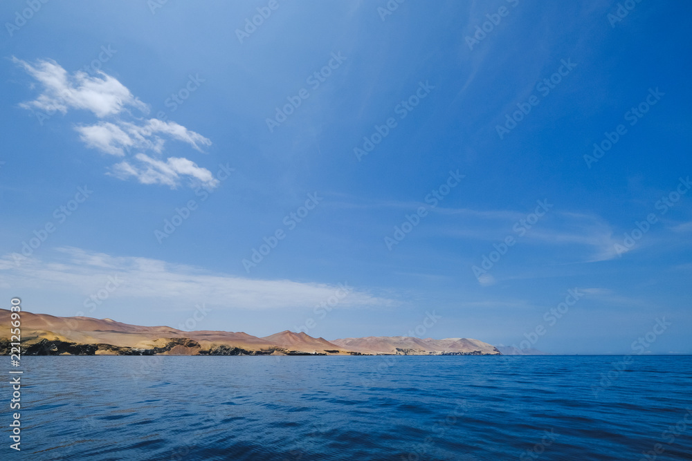 Natural reserve in Paracas, Peru. Blue sky, green sea, yellow cliffs, desert and ocean