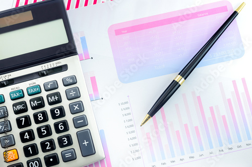 Calculator and Pen with Business Graphs finance document.