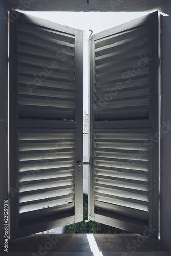 Sunlight behind white wood shutters