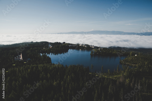Blue lake surrounded by dark green forest. Beautiful nature. Photo with edit space