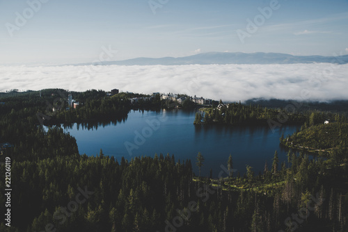 Blue lake surrounded by forest. Beautiful landscape. Photo with edit space