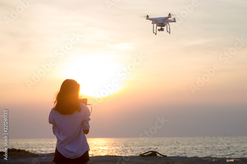 Slika na platnu Girl operating a drone with remote control