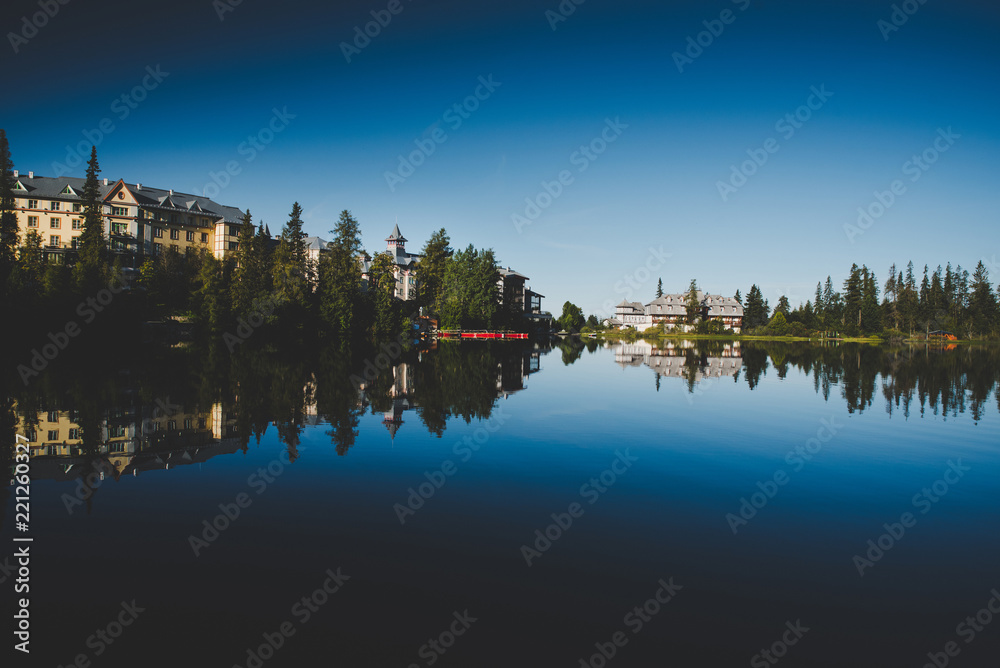 Luxury hotels by lake in mountains. Accommodation concept photo