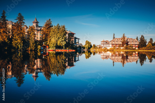 Luxury hotels by lake in mountains. Morning light
