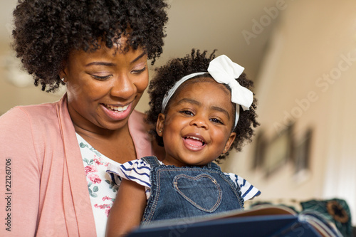 Mother reading a book to her little girl. photo