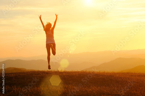 Fototapeta Naklejka Na Ścianę i Meble -  Happy woman with open arms jump on the peak of the mountain beautiful sunset background