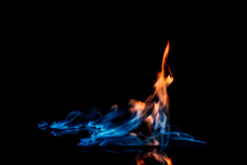 close up view of burning orange and blue flame on black background