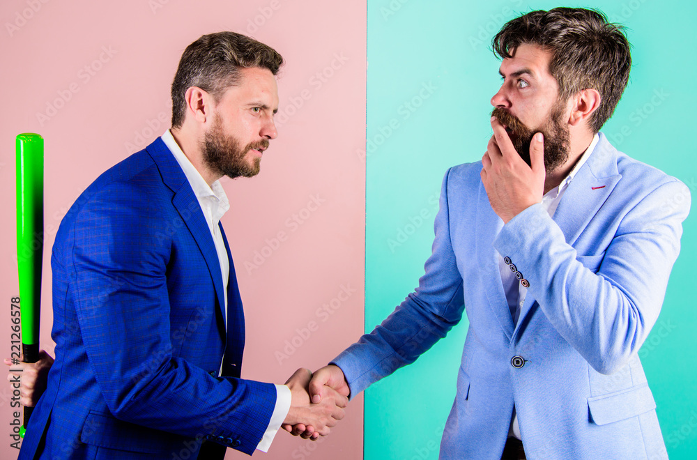 Fell into trap. Businessman hides bat behind back while shaking hands. Hidden threat concept. Business partners competitors office colleagues shaking hands. Tricky first impression. Hidden danger