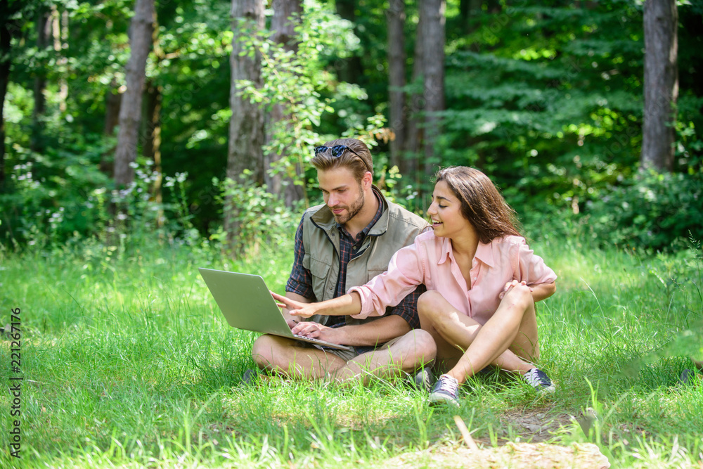 Man and girl looking at laptop screen. Couple youth spend leisure outdoors with laptop. Modern technologies give opportunity to be online and work in any environment conditions. Nature best workspace Man and girl looking at laptop screen. Couple youth spend leisure outdoors with laptop. Modern technologies give opportunity to be online and work in any environment conditions. Nature best workspace