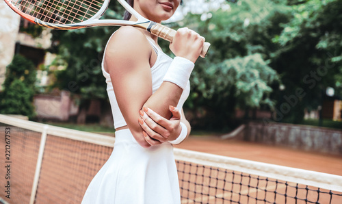 Pretty, young woman playing tennis in a city park on a lovely summer day © HBS
