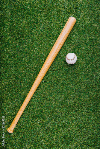 top view of baseball bat and ball arranged on green lawn