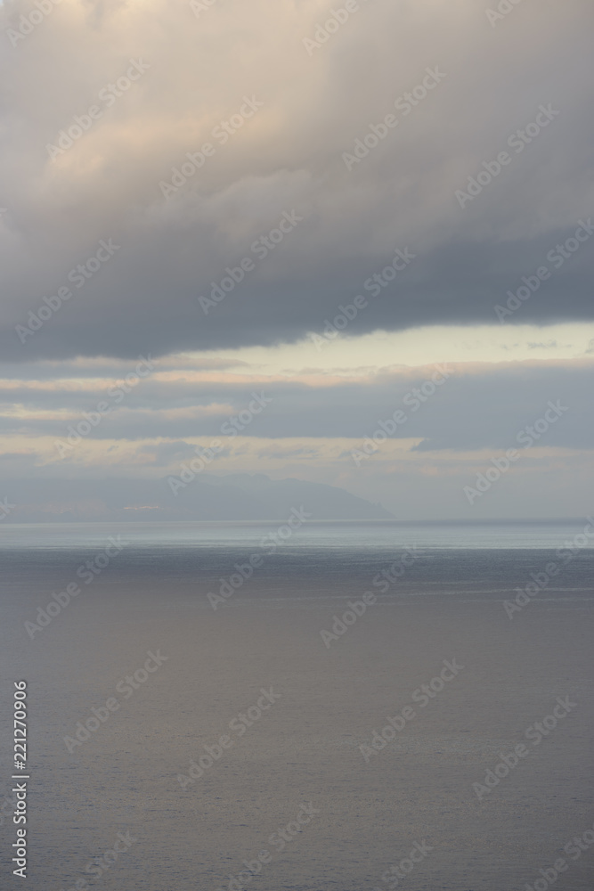 Blurred sunshine reflections in ocean and clouds over Canary Islands.