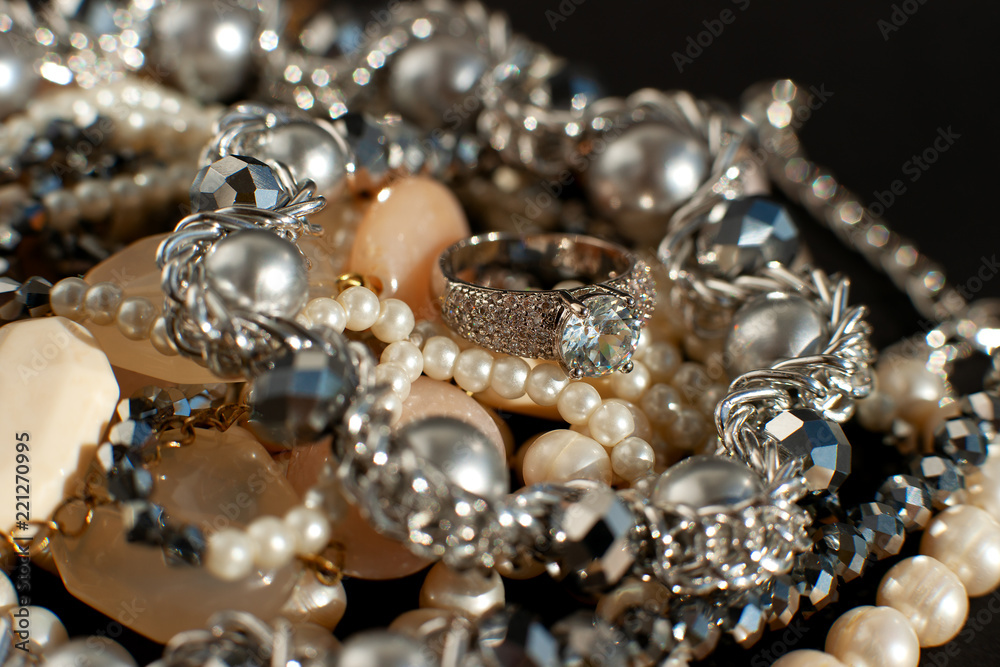 Jewelry shine on a black background. Macro. Jewelry for creating a fashionable female style. Pearls, a ring and beads shine. Accessories close-up. Jewelry shine on a black background. Macro. Jewelry for creating a fashionable female style. Pearls, a ring and beads shine. Accessories close-up.