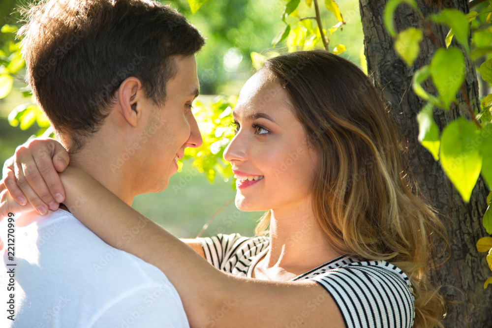 Happy couple hugging in a park in sunny day Happy couple hugging in a park in sunny day