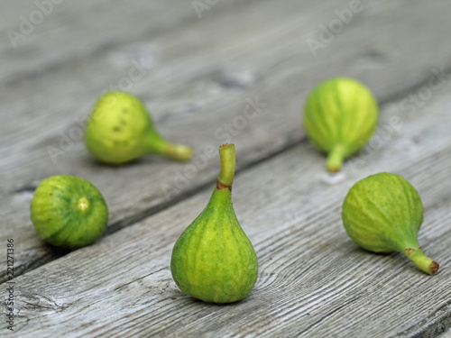 five little green figs on wooden background