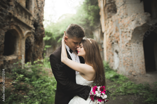 Happy newlyweds near the ancient castle on the walk © olegparylyak