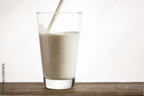 Fresh natural milk is poured into a glass.