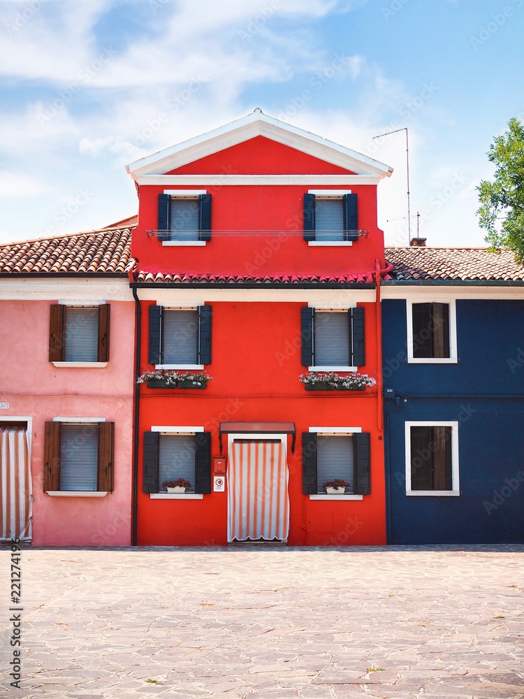 Street with colorful houses - red, blue, pink - in Venice, on the island of Burano, Hanging on the windows and drying clothes