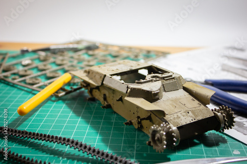 Scale model WW2 tank building on Cutting Plate with scale modelling tools. photo