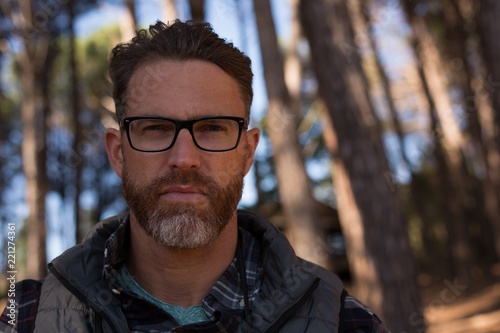 Confident man looking at camera in forest