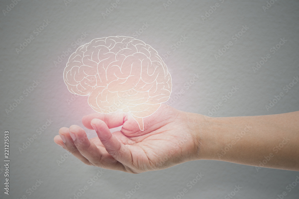 Man holding brain illustration against gray wall background. Concept with mental health protection and care. - obrazy, fototapety, plakaty 