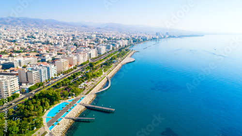 Aerial view of Molos Promenade park on coast of Limassol city centre,Cyprus. Bird's eye view of the jetty, beachfront walk path, palm trees, Mediterranean sea, piers, urban skyline and port from above photo