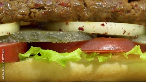 Turkish fast food Adana shish kebab in sandwich bread with vegetables. Rotating, slow motion, macro shot.