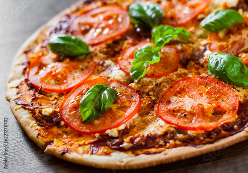 Pizza with Mozzarella cheese, Tomatoes, pepper, Spices and Fresh Basil. Italian pizza. Pizza Margherita or Margarita. on wooden background