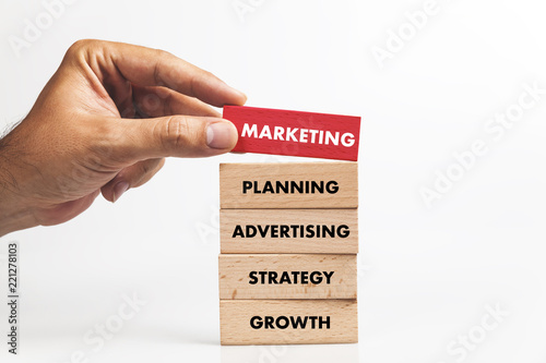 Businessman Building MARKETING concept with Wooden Blocks