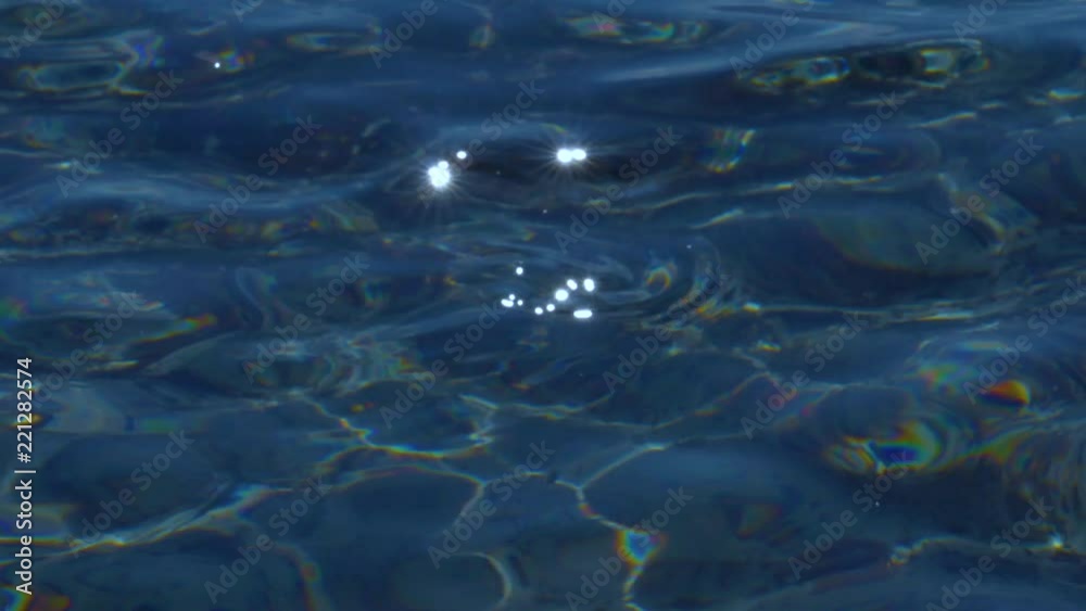CLOSE UP: Small ocean waves sparkle and glimmer in the bright summer sunshine. Cinematic close up of crystal clear sea water gently moving and shining on a sunny day. Idyllic shot of glittering lake. CLOSE UP: Small ocean waves sparkle and glimmer in the bright summer sunshine. Cinematic close up of crystal clear sea water gently moving and shining on a sunny day. Idyllic shot of glittering lake.