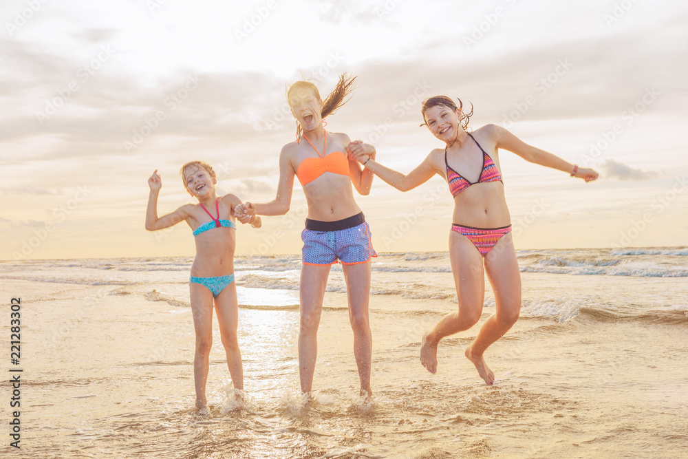 Kids having fun at sunset beach - friendship freedom beach summer holiday concept