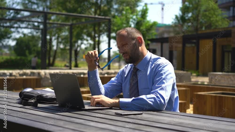 Businessman having head pain during work on laptop by table at city park
Businessman having head pain during work on laptop by table at city park