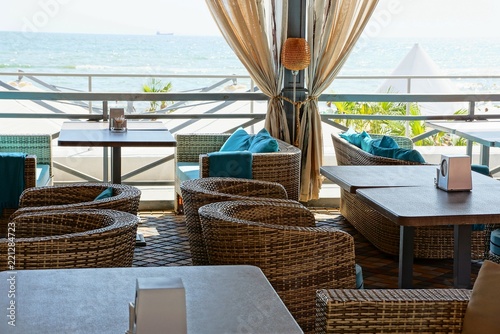 part of the terrace of the restaurant with tables and chairs on the background of the sea © butus
