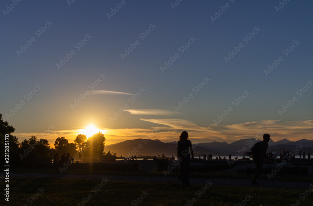 Fototapeta premium Person enjoying sunset, Kitsilano Beach Park, Vancouver, BC, Canada.