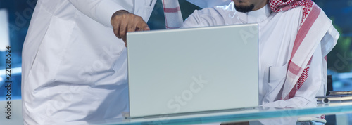 Middle eastern businessmen at desk working on a laptop