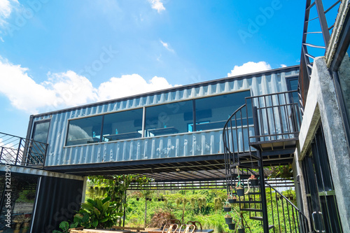 Modern metal building made from shipping house containers and blue sky background .