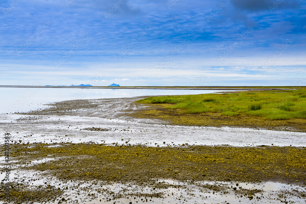 Beautiful isolated green colored Iceland lake with blue skies and puffy clouds. Reflection on water. Beautiful isolated green colored Iceland lake with blue skies and puffy clouds. Reflection on water.