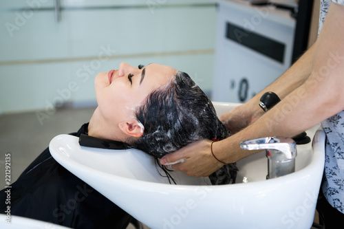beautiful brunette girl washing her hair in the hairdresser's