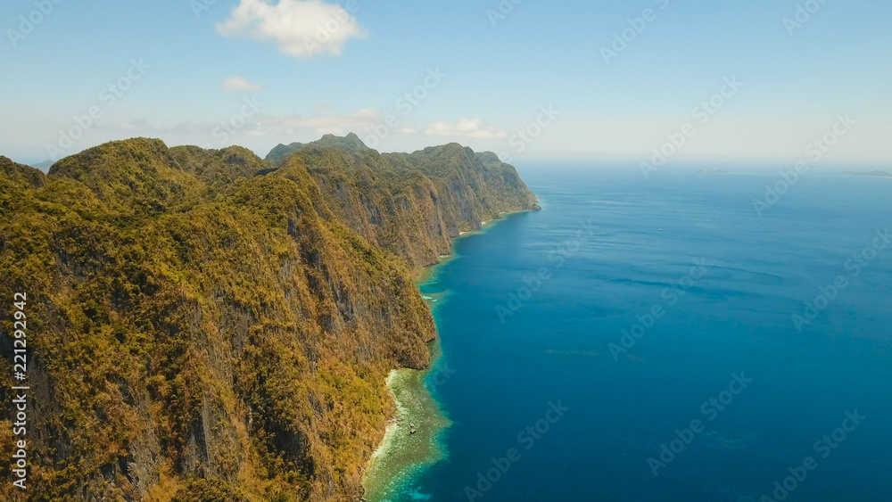 Aerial view: Lagoon with blue, azure water in the middle of small islands and rocks. Beach, tropical island, sea bay and lagoon, mountains with forest, Palawan, Coron. Busuanga. Seascape, tropical