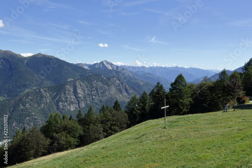 A landscape of green mountains, with pines and firs, rocks and glaciers, in the Vigezzo Valley, northern Italian Alps