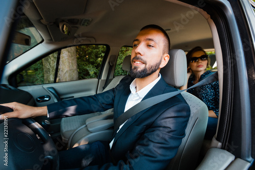 Taxi driver driving a car with businesswoman © Snapic.PhotoProduct
