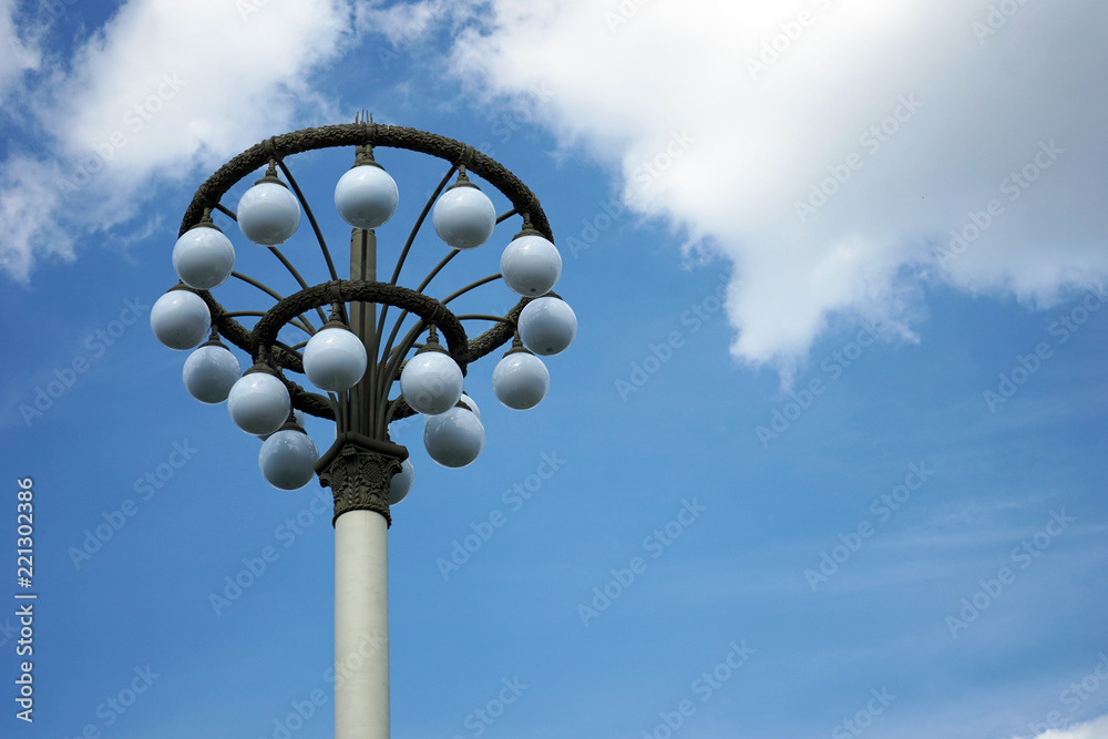 Street lamp with white round shades on a blue sky background. Street lamp with white round shades on a blue sky background.