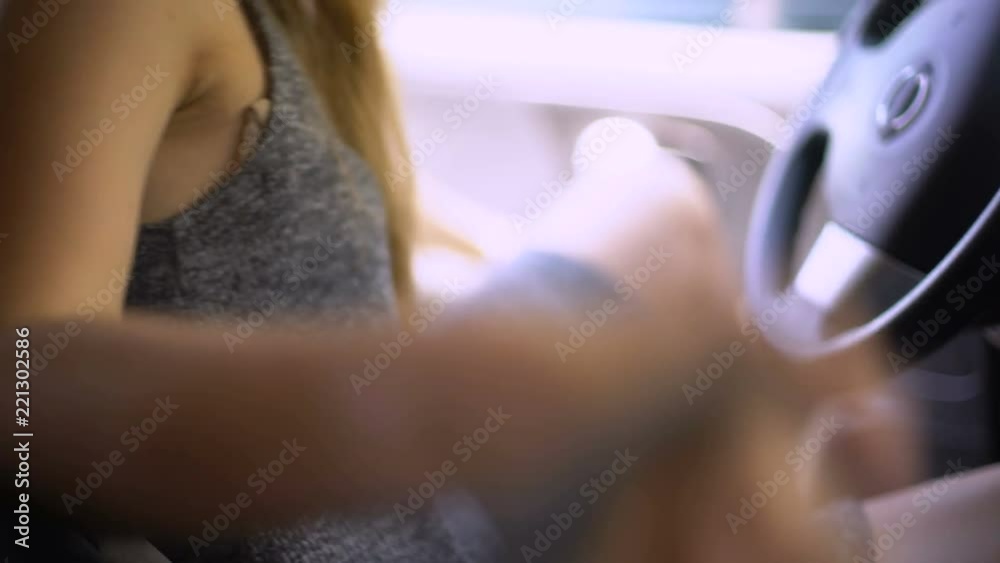 Male criminal threatening young female driver with gun, sitting in car behind Male criminal threatening young female driver with gun, sitting in car behind