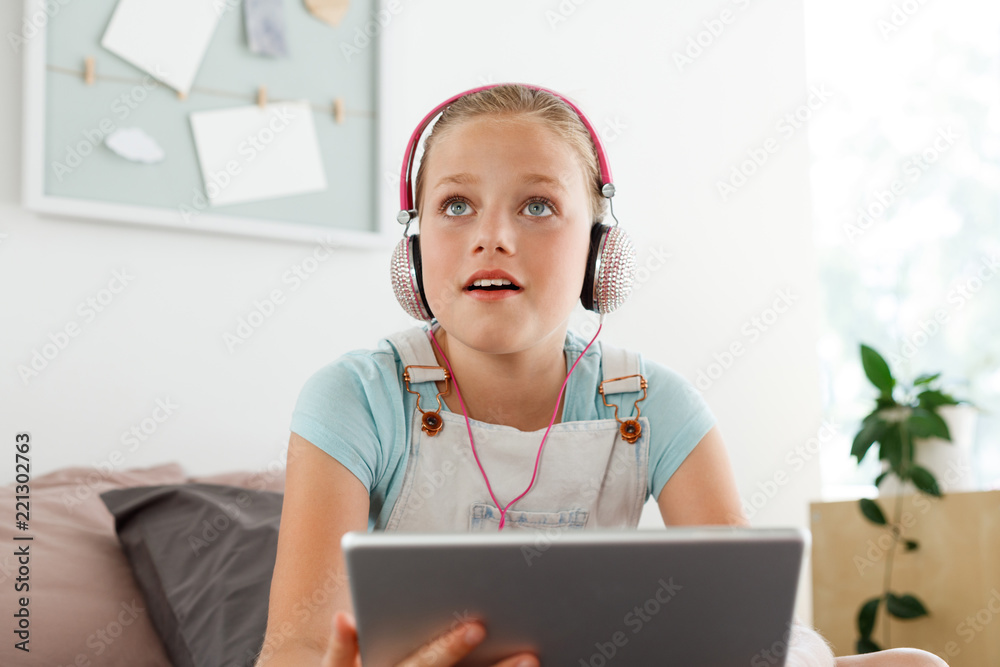 Cute girl using digital tablet in her bedroom Cute girl using digital tablet in her bedroom