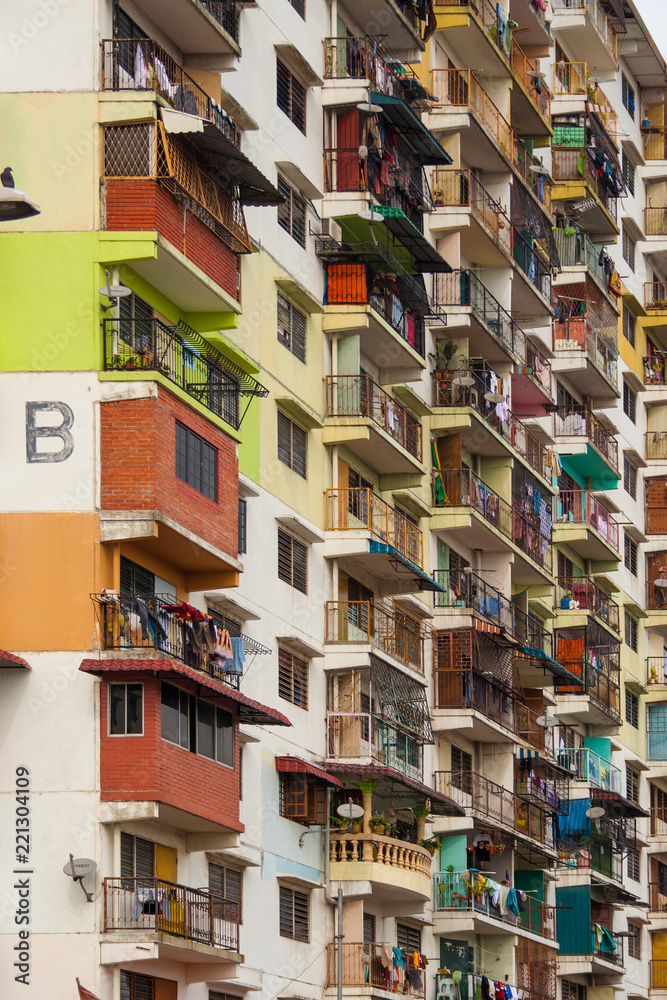 Close-up of a low cost flat in Malaysia. The colourful facade with its bright paints, different balconies and hanging clothes makes it interesting.