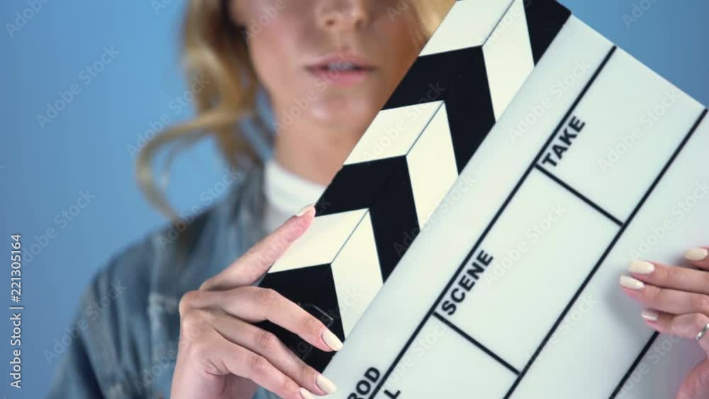 Pretty blonde actress posing for audition with movie clapper board, casting