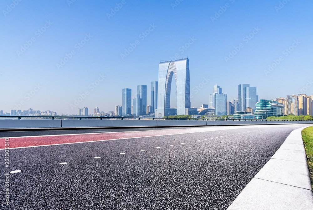 empty asphalt road with city skyline